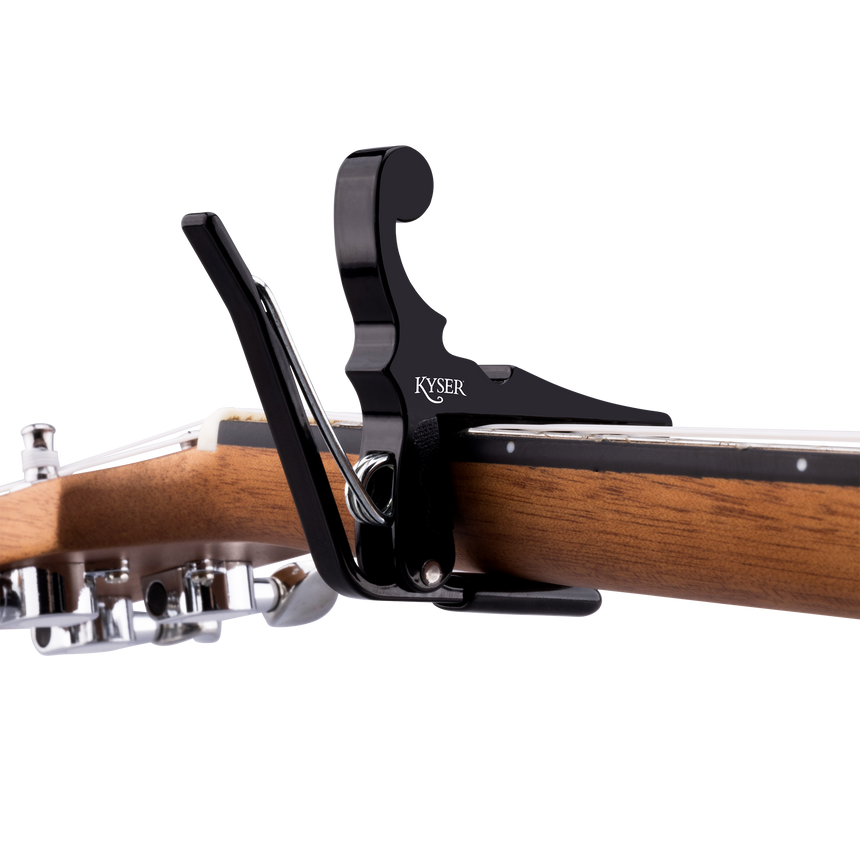 Black Kyser KBMBA Quick-Change capo for banjo, mandolin and ukulele – attached to a ukulele neck.
