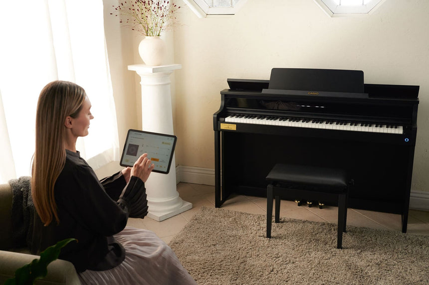 Casio AP-750BK, schwarz – Wohnraumszene mit Bedienung der Musik-App auf einem Tablet.